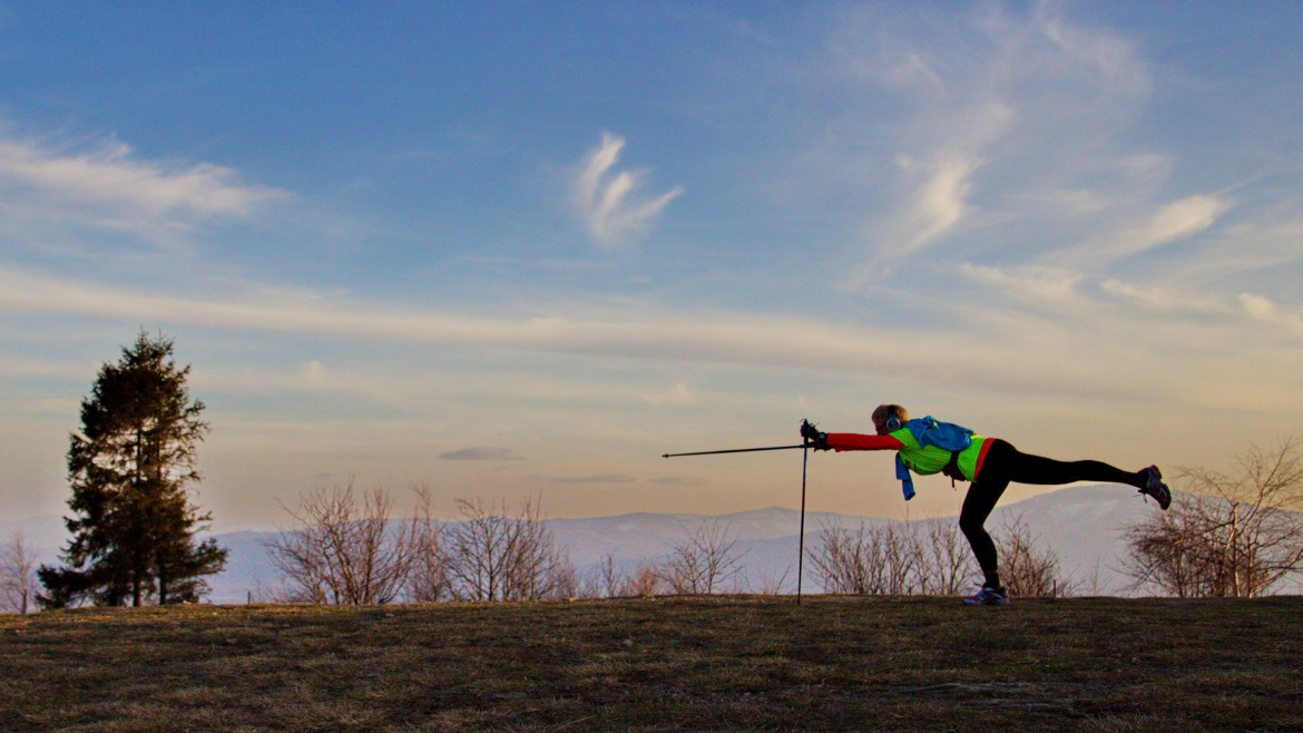 Zdjęcie osoby z kijami do nordic walking. W tle Beskidy